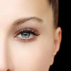 Closeup studio shot of a beautiful young woman and man posing against a grey background